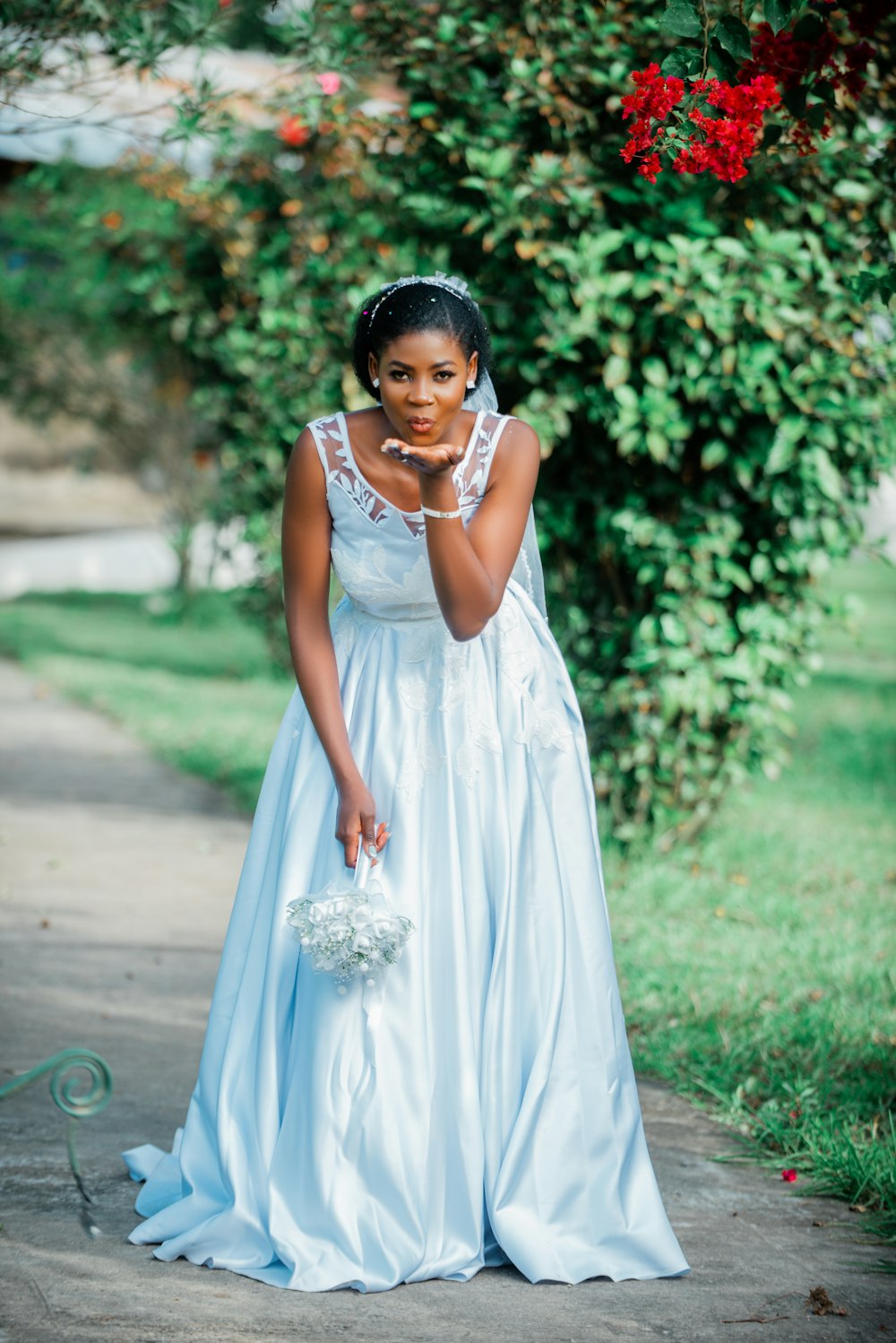 a woman in a blue dress holding a white bouquet