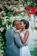a bride and groom embracing under a tree