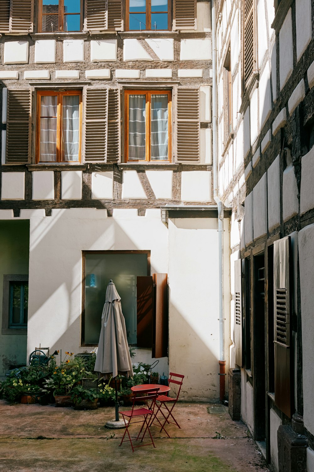 a patio with a table and chairs in front of a building