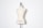 A beige dress form or mannequin torso is placed in front of a plain white background. The top of the mannequin has a black neck and features the inscription 'HAUTE COUTURE STOCKMAN PARIS'. The focus is on the elegant shape and neutral tone of the form.