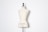 A beige dress form or mannequin torso is placed in front of a plain white background. The top of the mannequin has a black neck and features the inscription 'HAUTE COUTURE STOCKMAN PARIS'. The focus is on the elegant shape and neutral tone of the form.