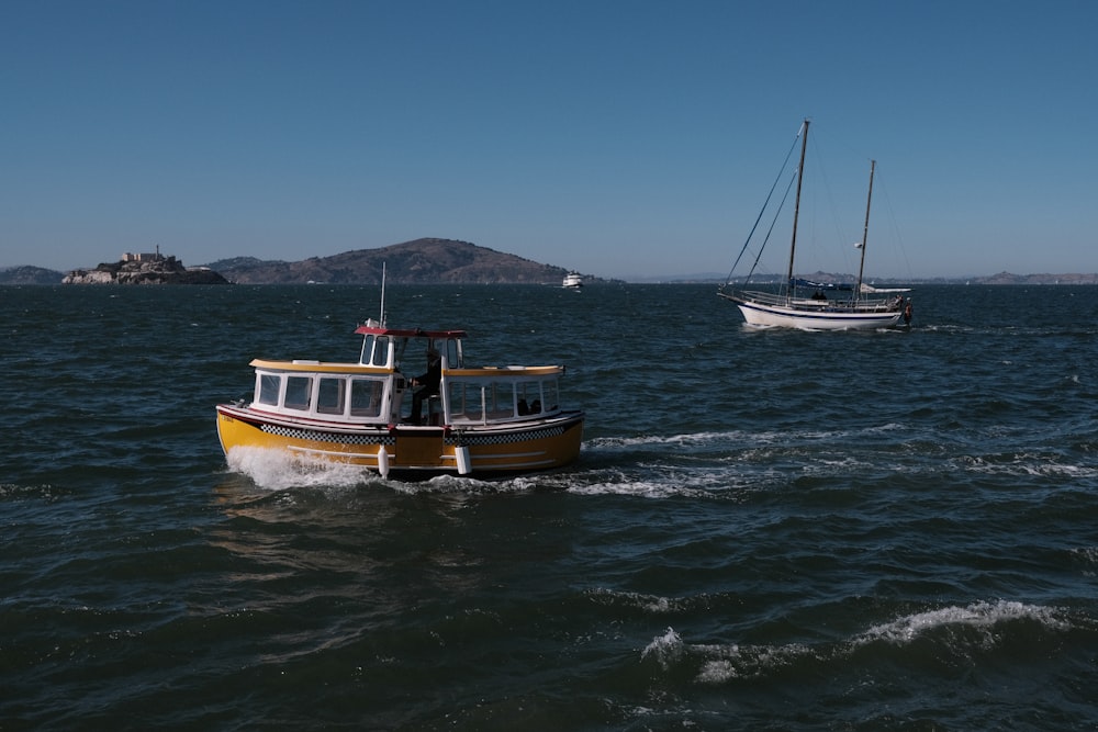 two boats in the water with a mountain in the background