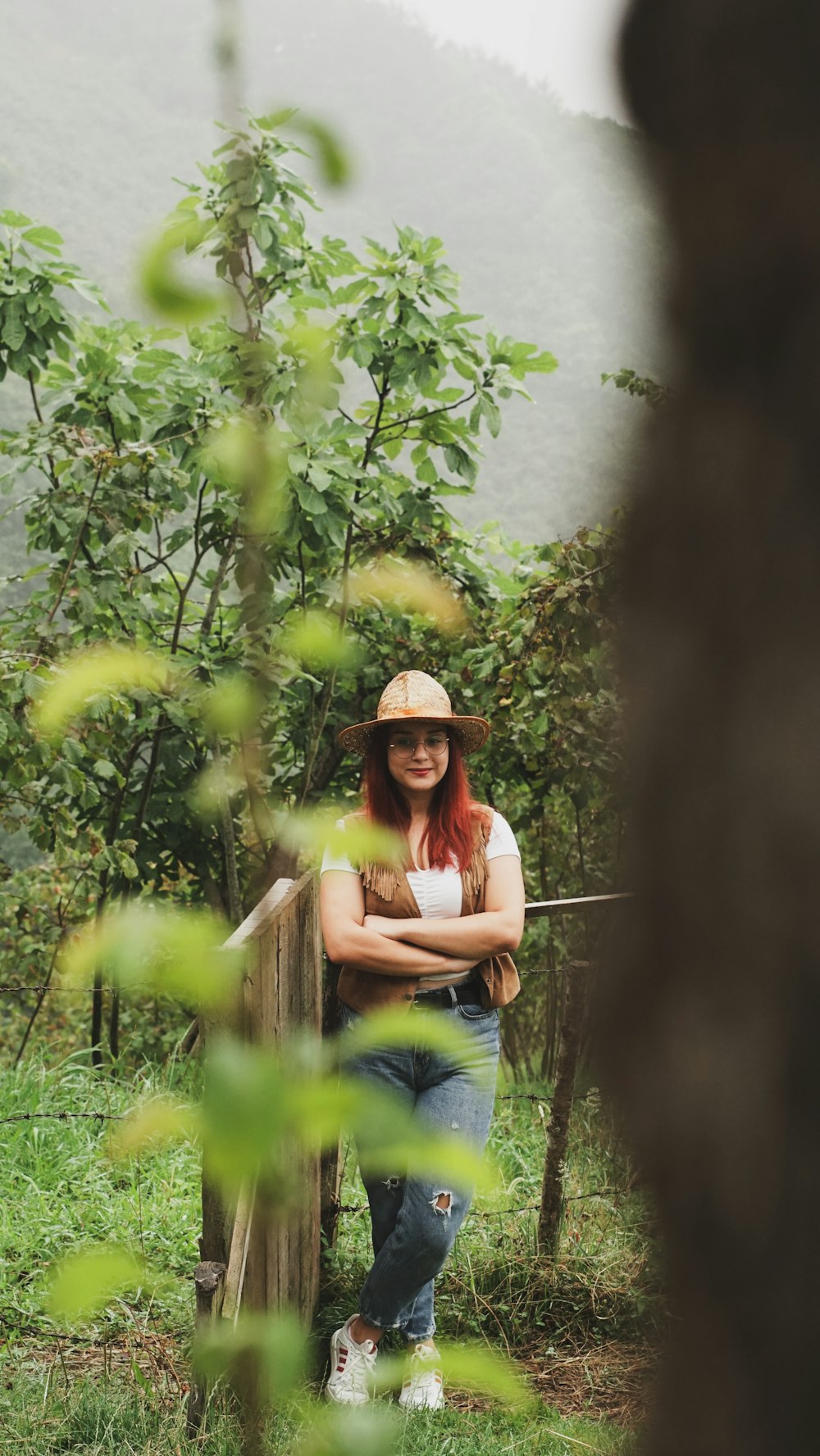 a woman wearing a hat sitting on a wooden bench