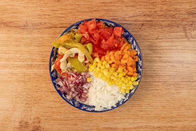 A rustic wooden bowl filled with colorful mixed rice grains from Asia.