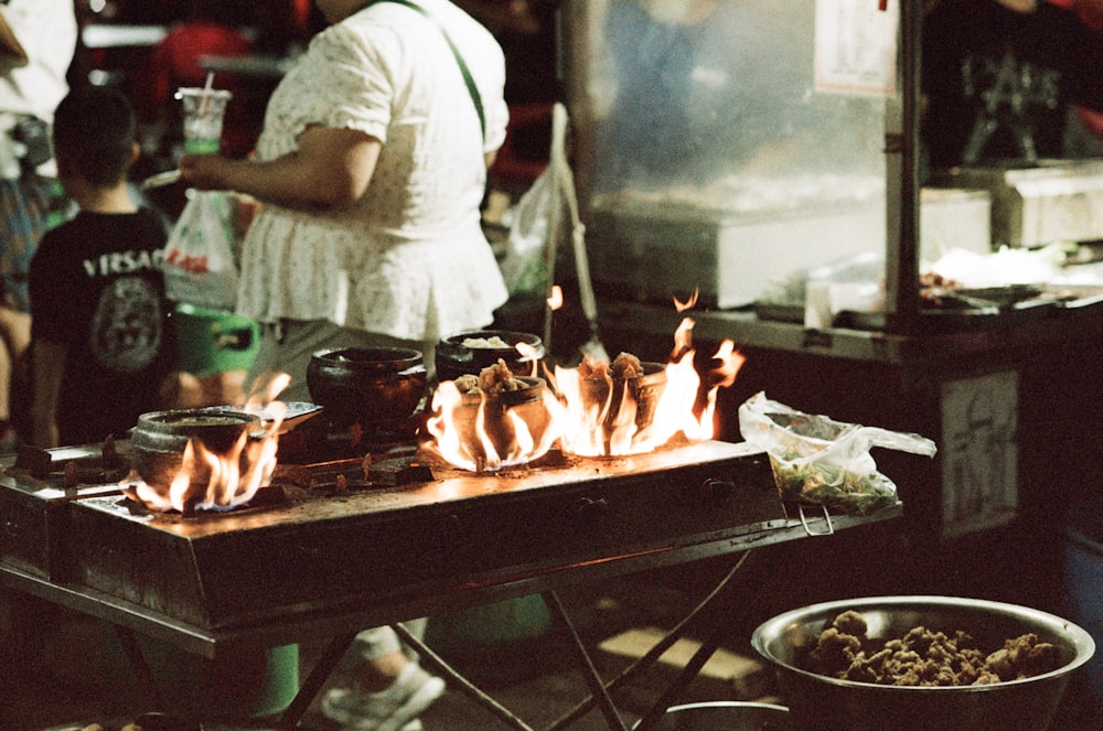 a person cooking food on a grill in a kitchen