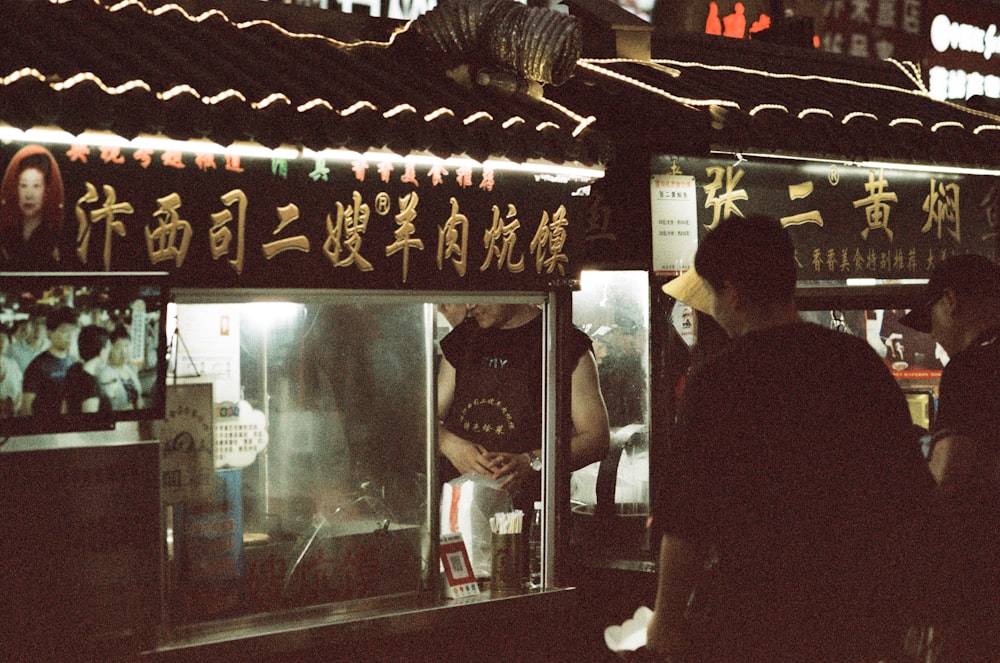 a group of people standing outside of a building at night