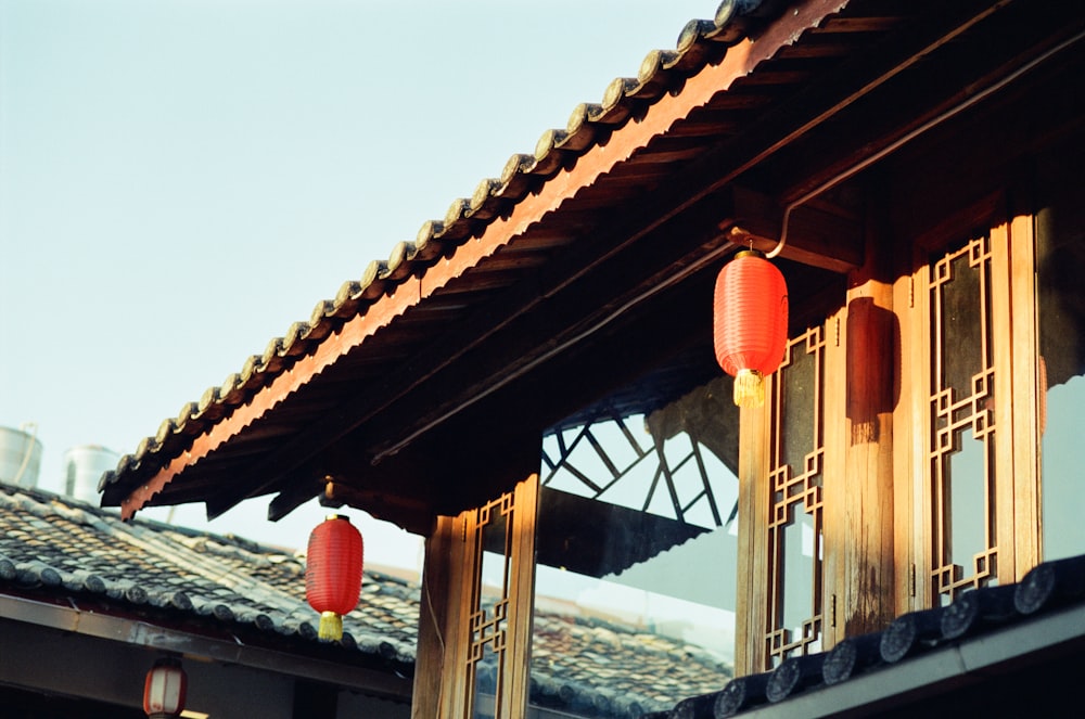 a couple of red lanterns hanging from the side of a building