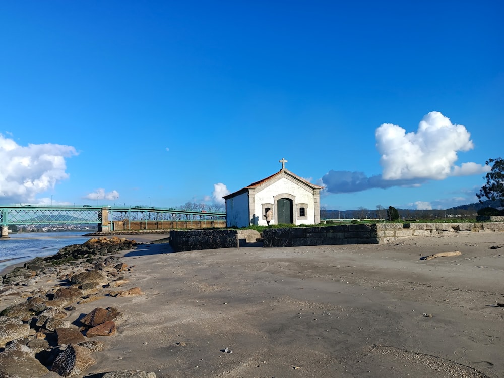 a small white church sitting on top of a sandy beach