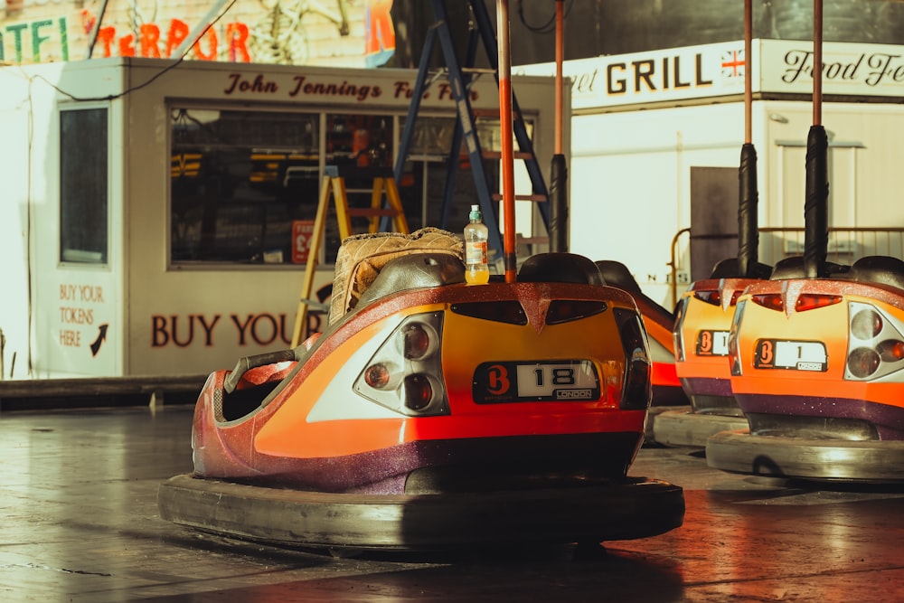 a couple of bumper cars sitting on top of a wet ground