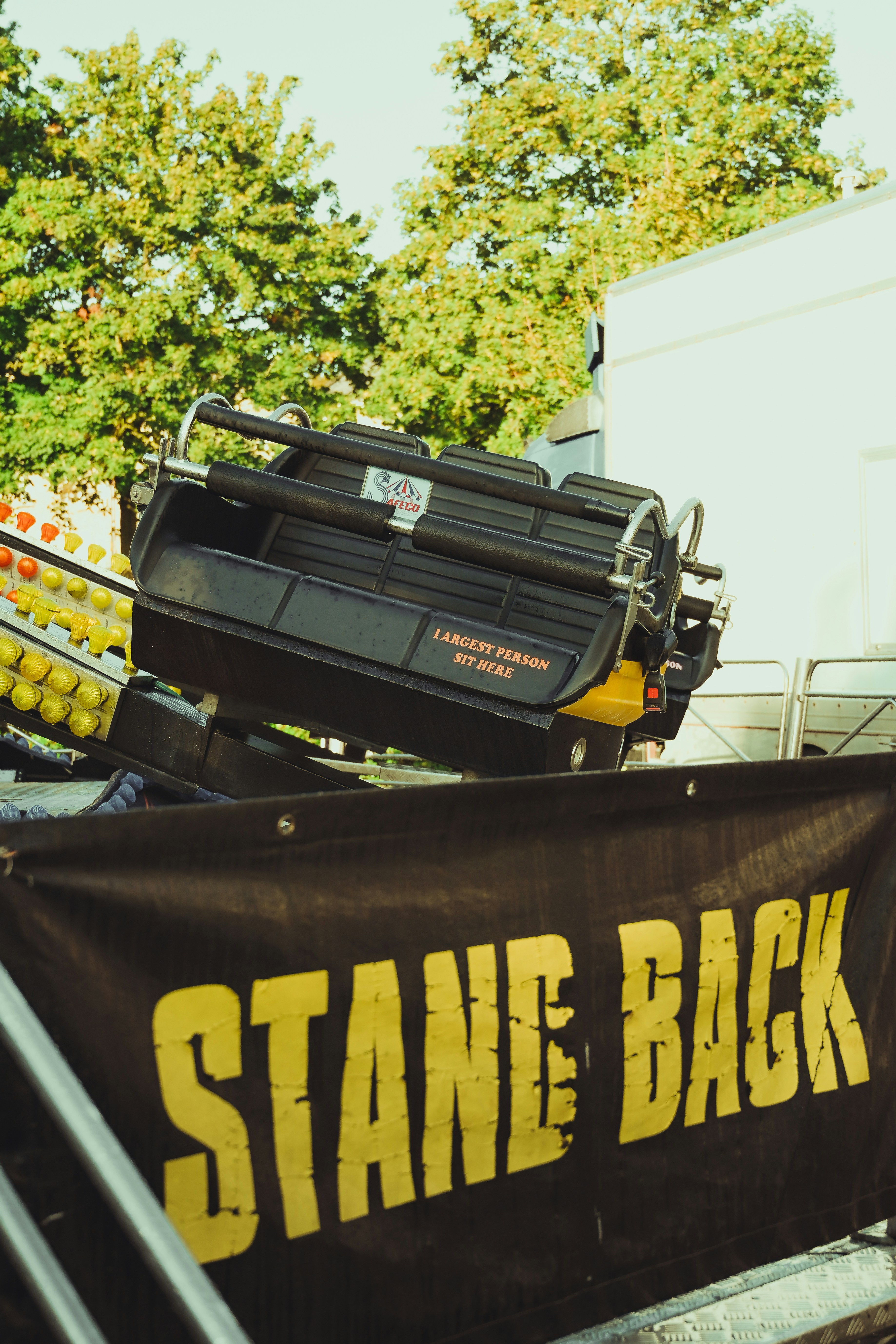 a sign that says stand back next to a truck