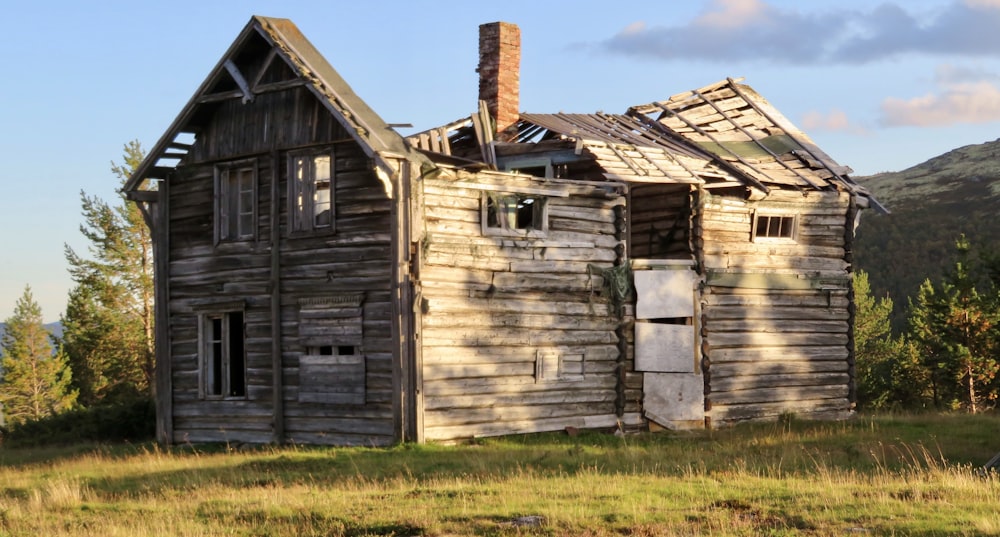 an old run down house in the middle of a field