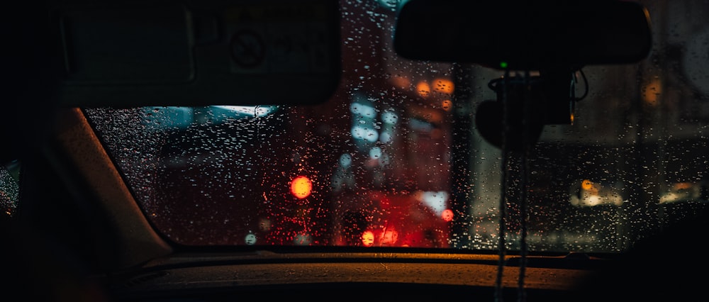 une vue d’une rue pluvieuse depuis la fenêtre d’une voiture