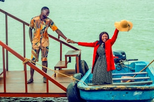 a man and a woman standing on a boat