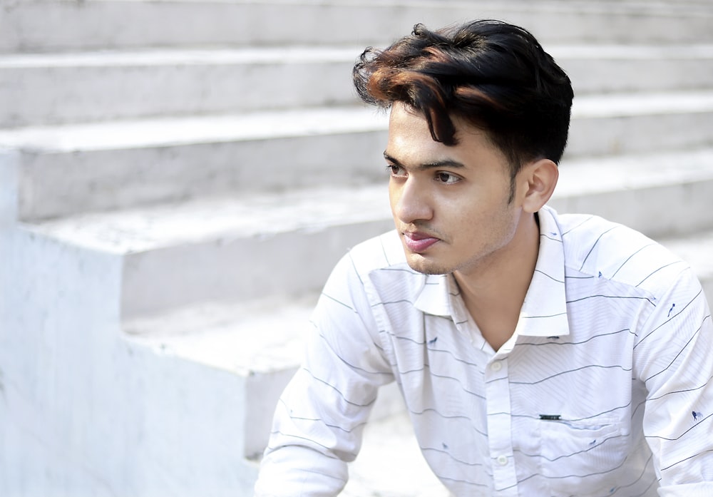 a young man sitting on a set of stairs