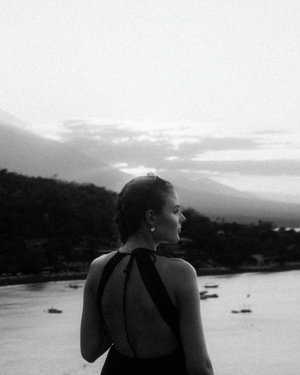 a woman in a bathing suit looking out over a body of water