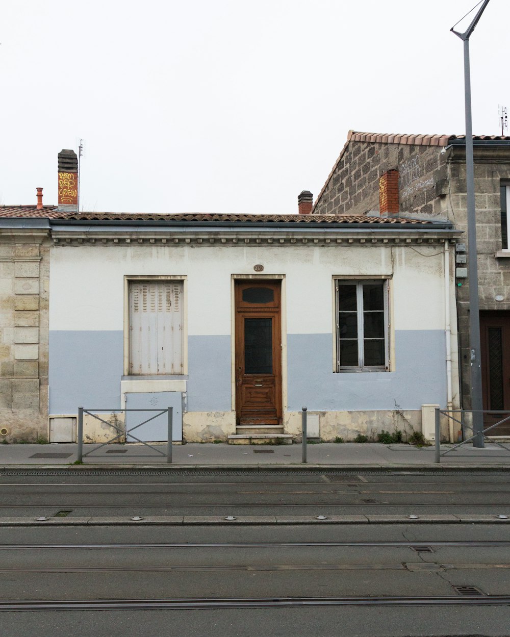 a white building with a brown door and windows