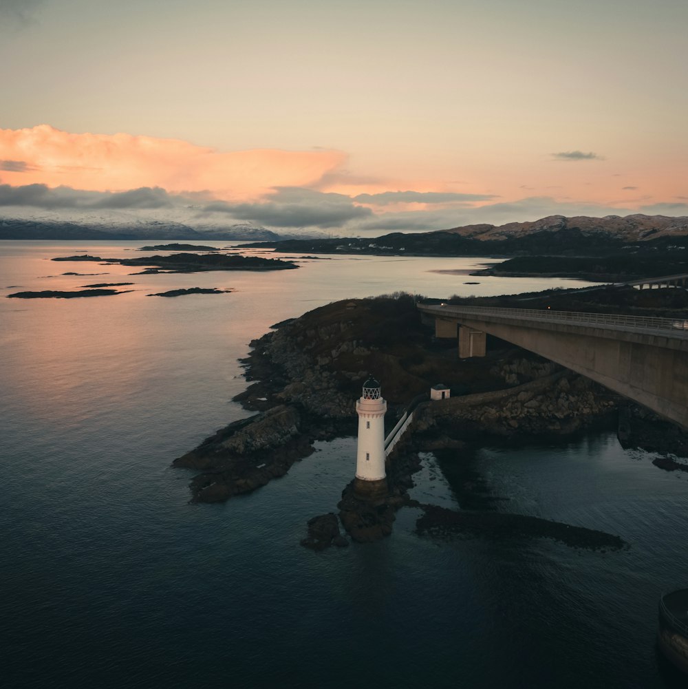 an aerial view of a lighthouse in the middle of a body of water