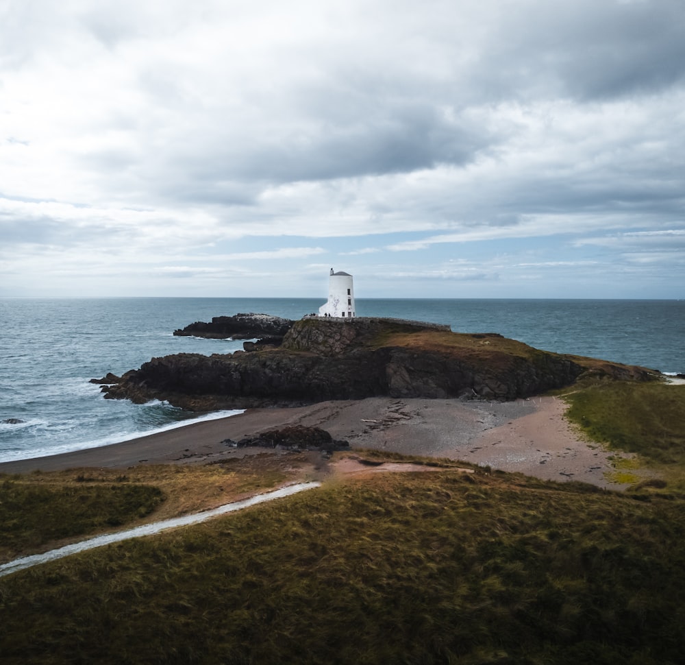 a lighthouse on a small island in the middle of the ocean