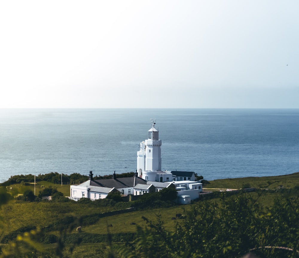 Un grand bâtiment blanc assis au sommet d’une colline verdoyante