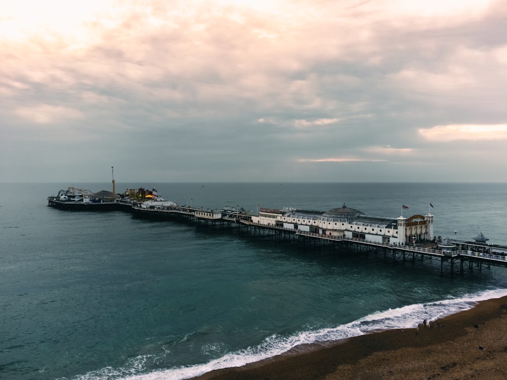 a pier on the ocean with a cloudy sky