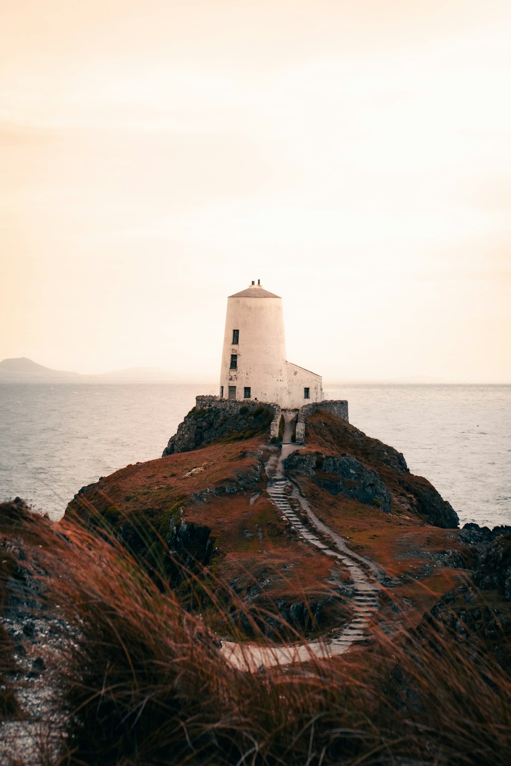 a lighthouse on a small island in the middle of the ocean