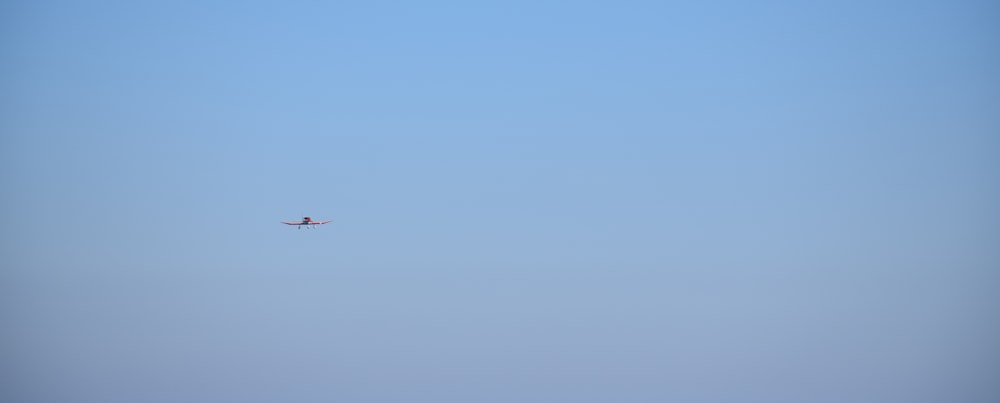 an airplane is flying in the blue sky