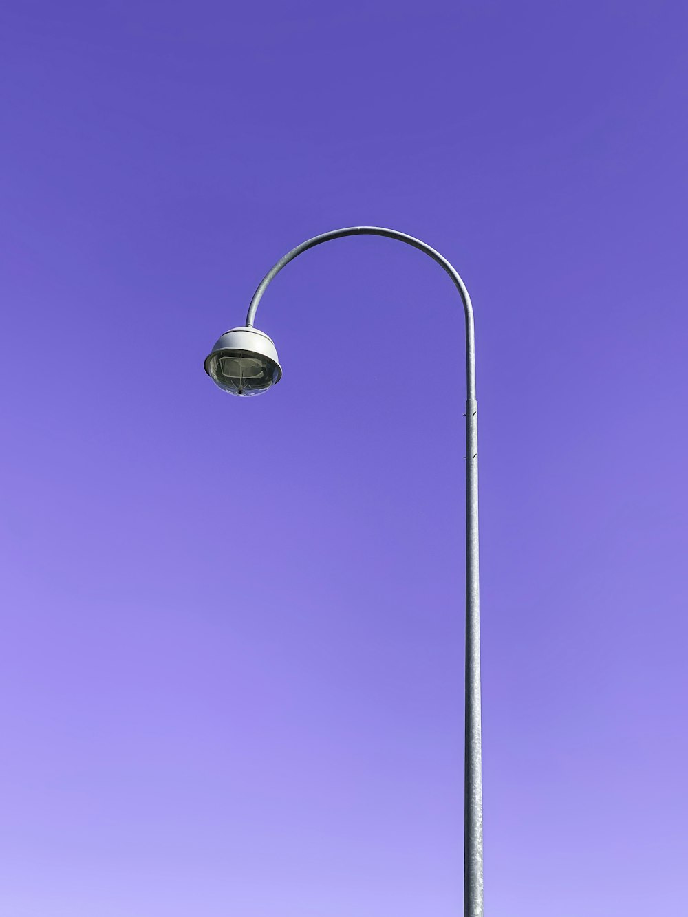 a street light with a purple sky in the background