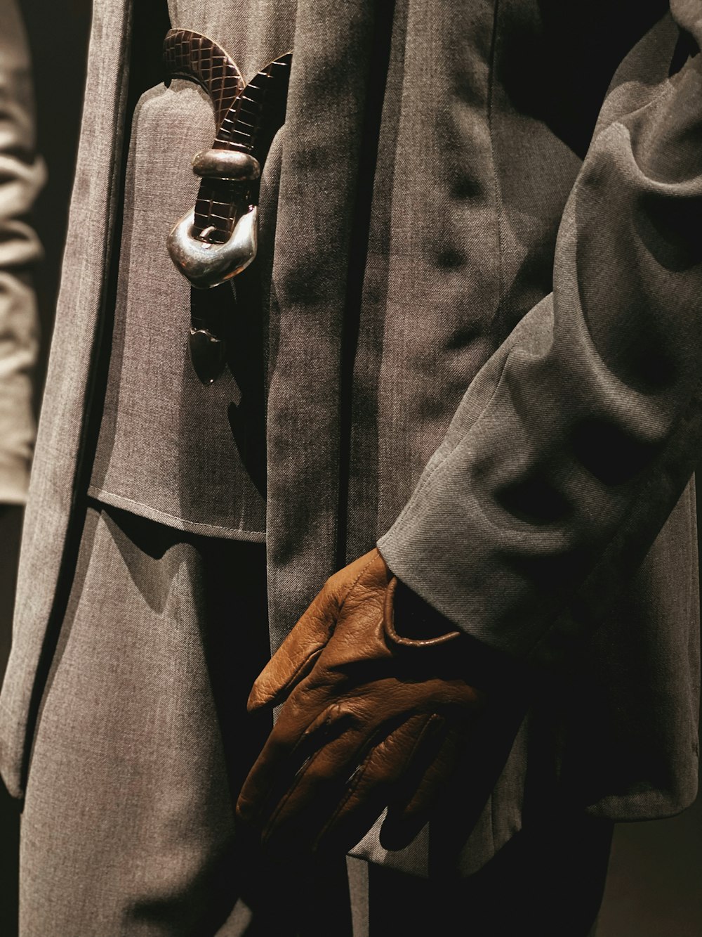 a man in a suit and brown gloves