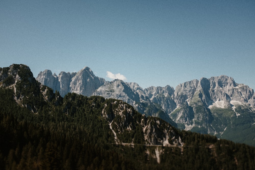 a view of a mountain range with trees and mountains in the background