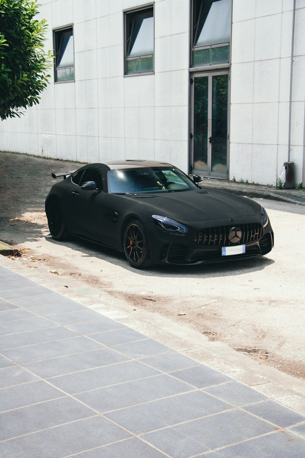 a black sports car parked in front of a building