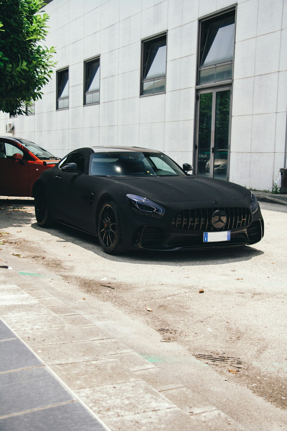 Un'auto sportiva nera parcheggiata davanti a un edificio