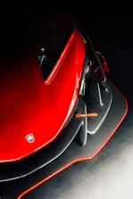 Close-up of a Corvette C8’s carbon fiber hood and aerodynamic side panels under soft lighting.