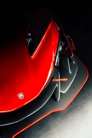 Close-up of a Corvette C8’s carbon fiber hood and aerodynamic side panels under soft lighting.