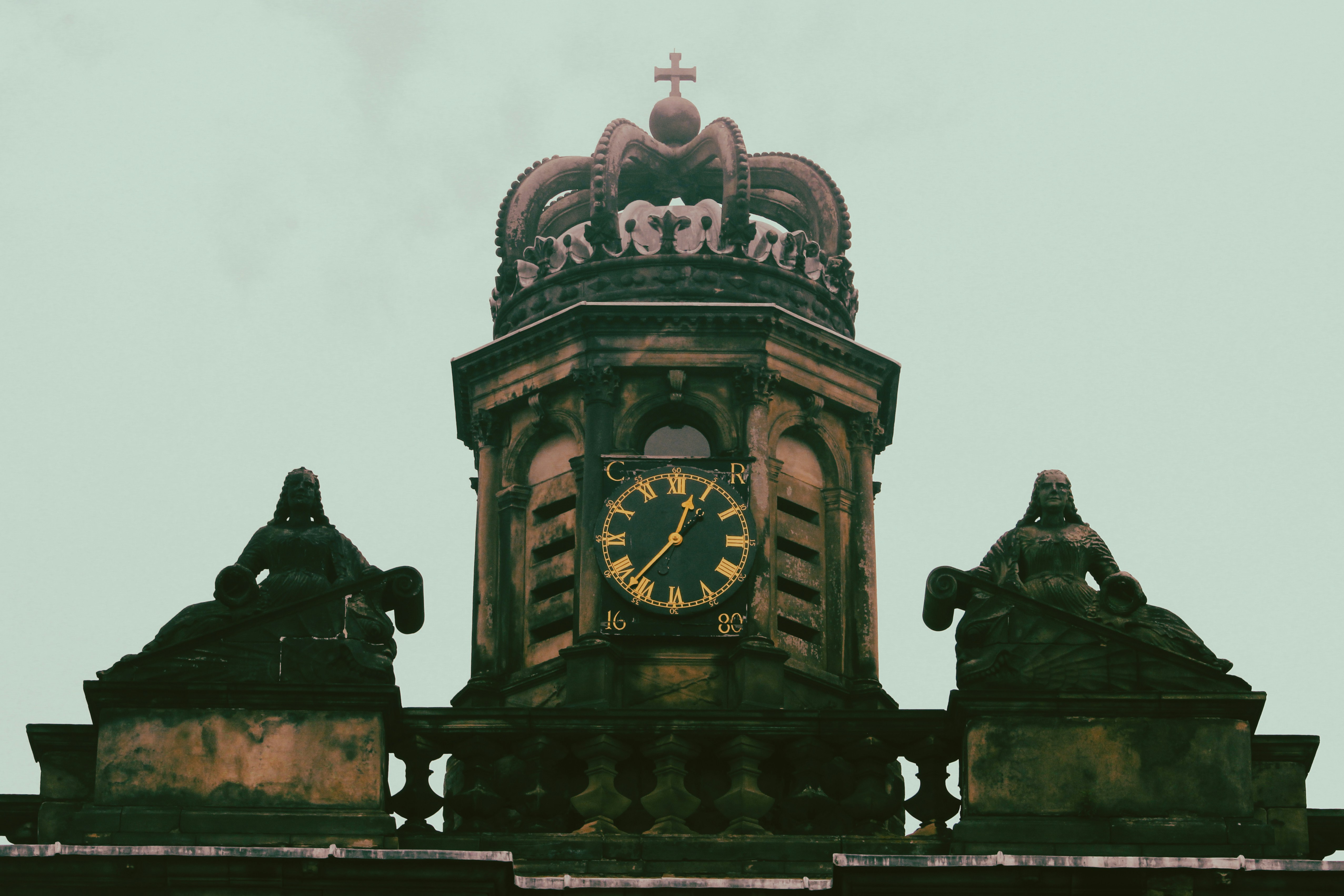 a clock tower with statues on top of it, 