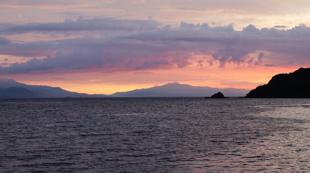 a large body of water with mountains in the background