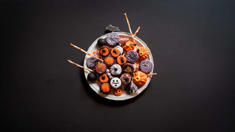 Un plato de dulces de Halloween sobre una mesa negra