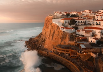 a view of a town on a cliff overlooking the ocean