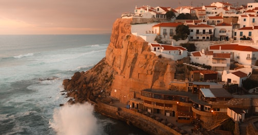 a view of a town on a cliff overlooking the ocean