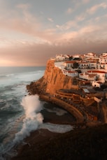 a view of a town on a cliff overlooking the ocean