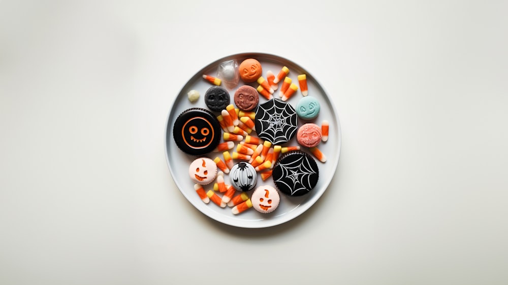 a white plate topped with halloween cookies and candies