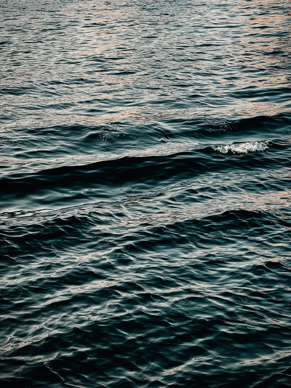 a large body of water with a boat in the distance