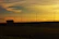 A heavy-duty truck navigating a complex highway interchange at sunset.