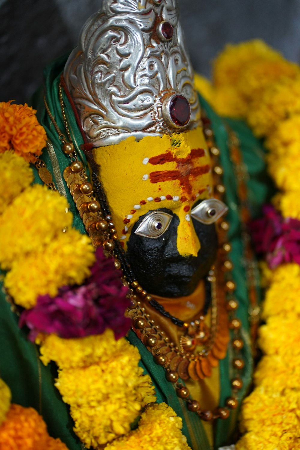 a close up of a statue of a person surrounded by flowers