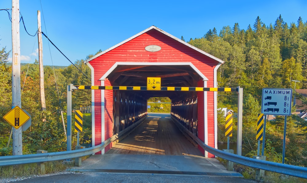a red covered bridge with yellow and black stripes