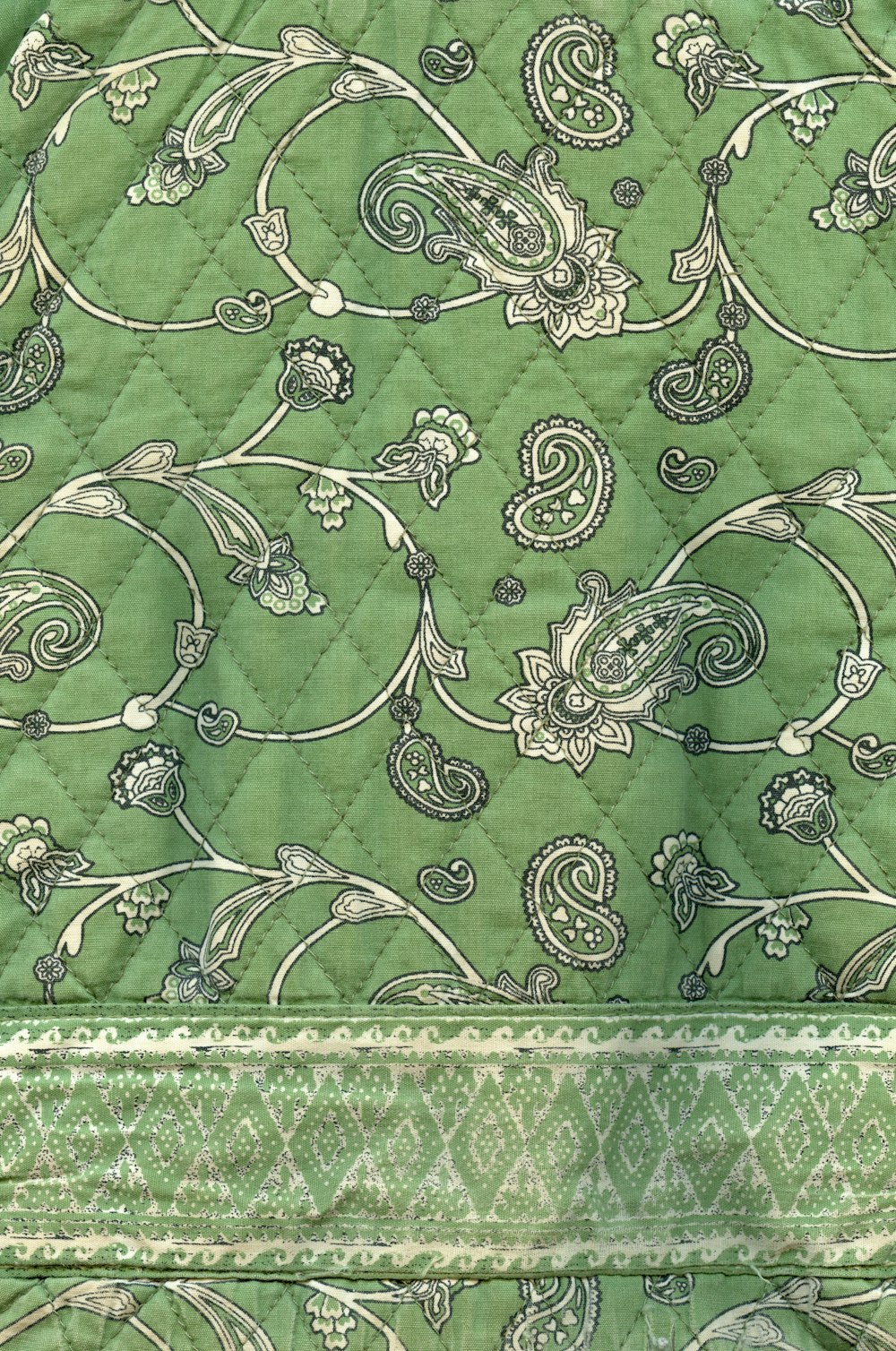 a close up of a green and white quilt