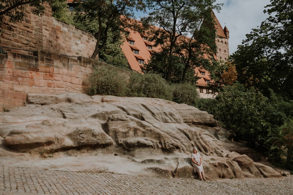 a woman standing in front of a large rock formation