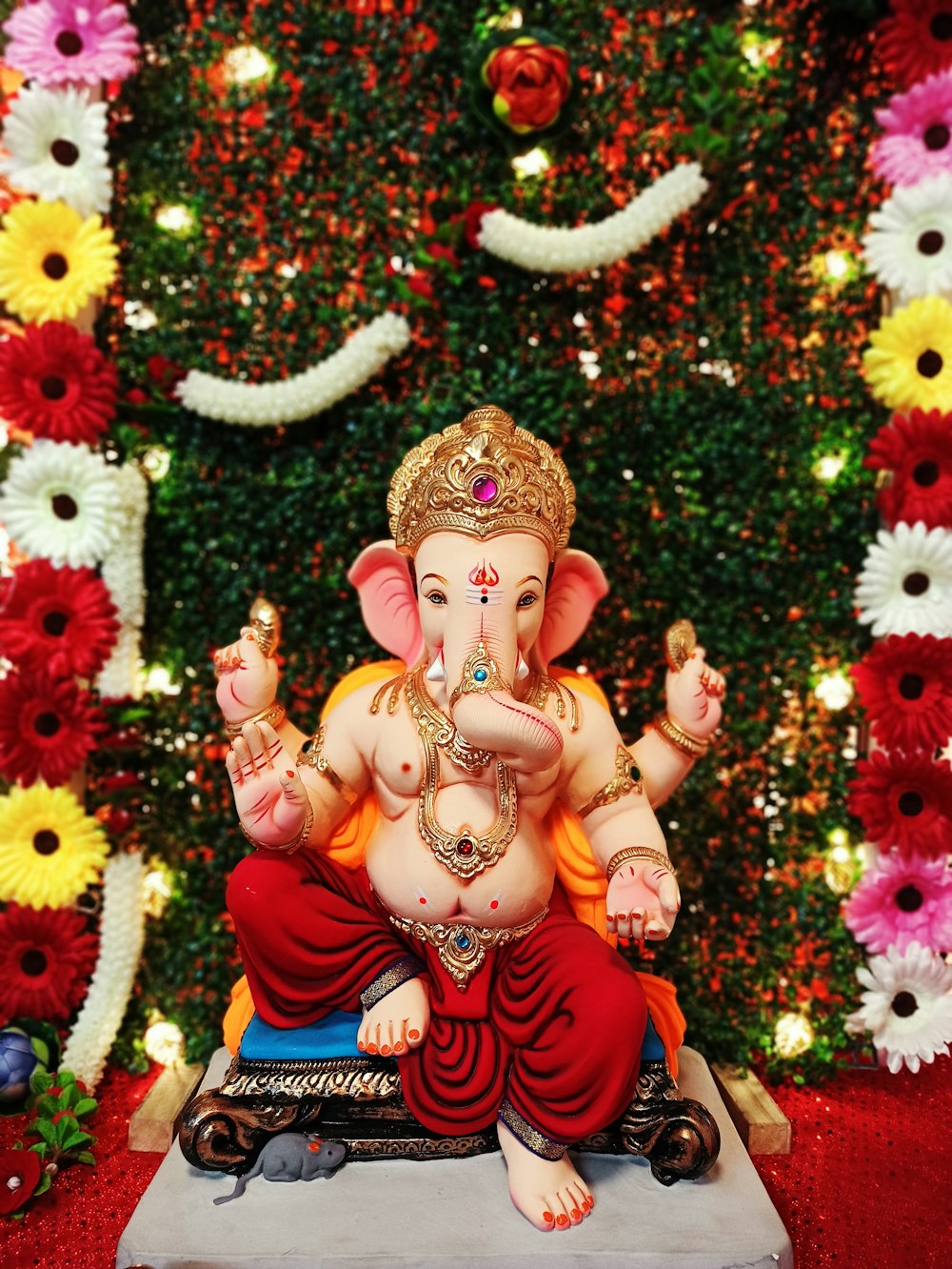 a statue of an elephant sitting in front of a christmas tree