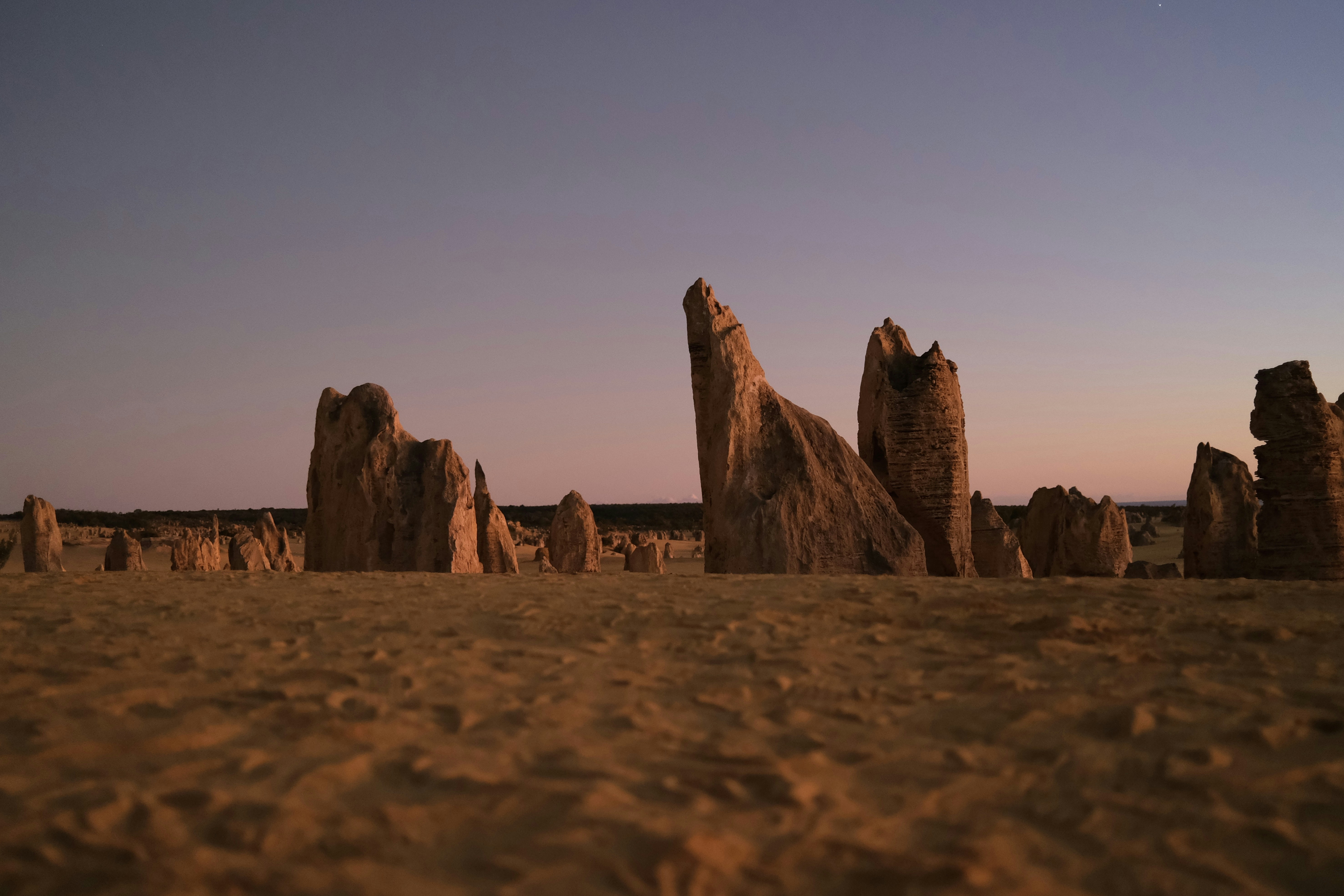 a group of rocks sitting on top of a sandy beach