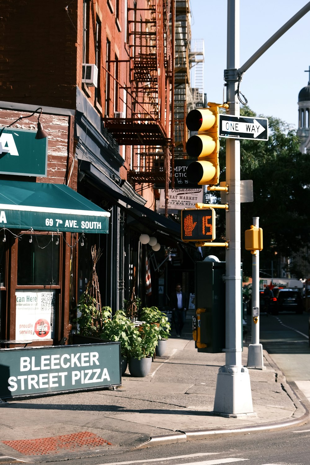 a street corner with a pizza shop and a traffic light