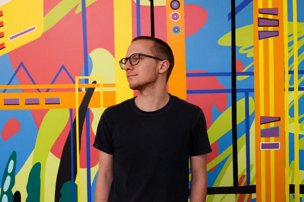a man standing in front of a colorful wall